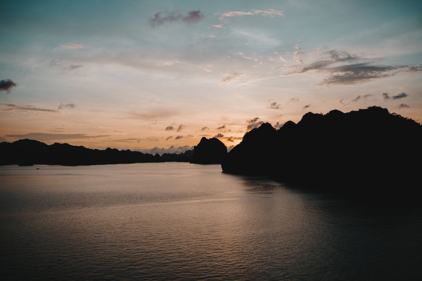Sunset over Halong Bay with boat silhouettes