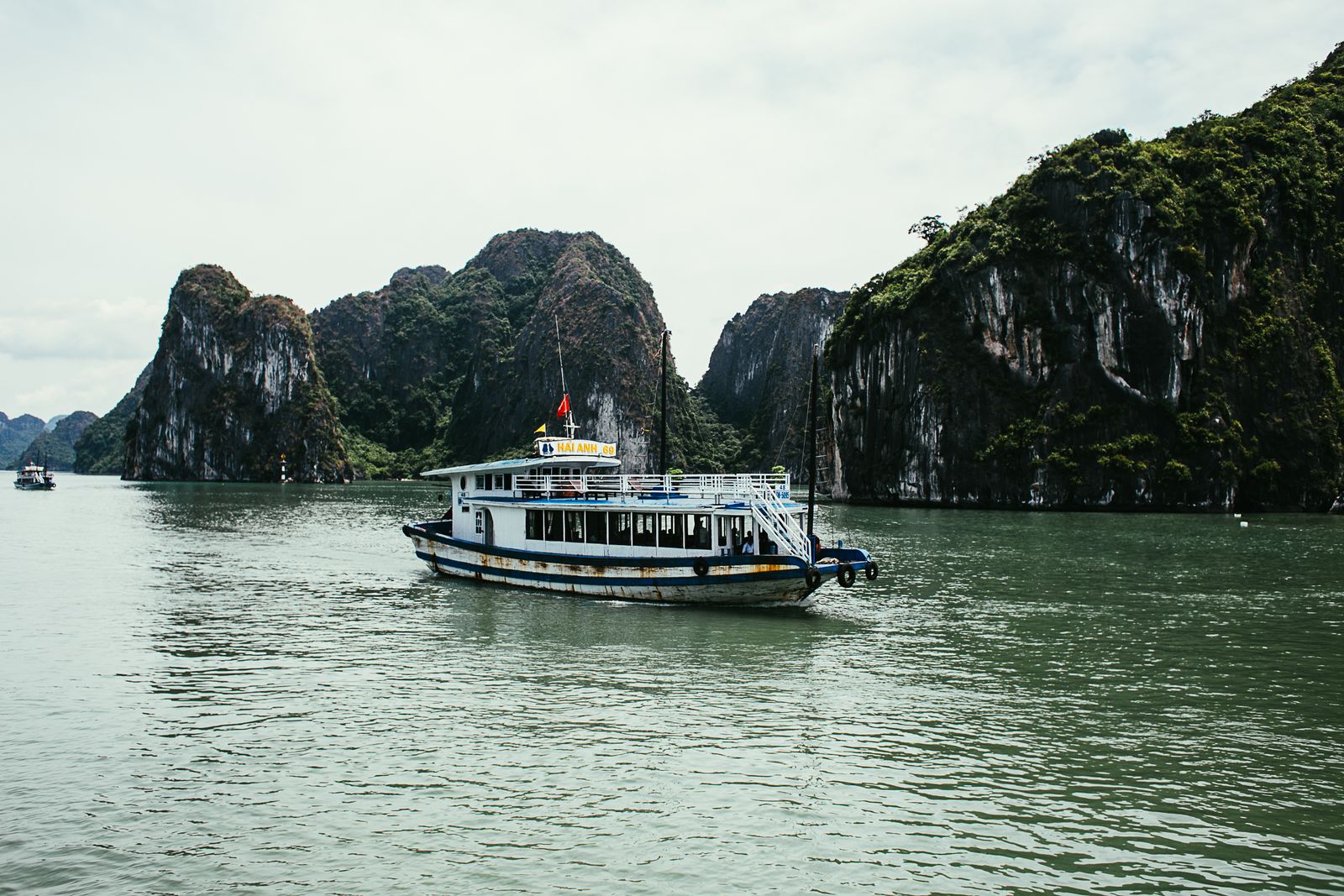 Overnight cruise boat anchored between karsts in Halong Bay