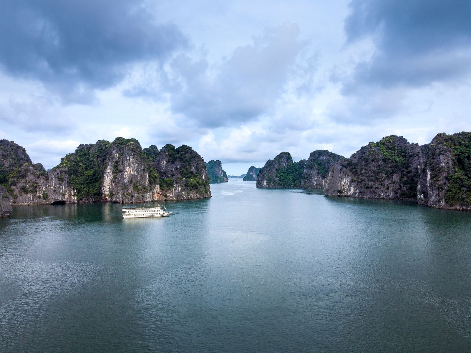 Aerial view of limestone islands and a cruise boat in Halong Bay, Vietnam